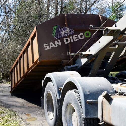 A sturdy dump truck with a vibrant design, positioned on a city street, showcasing its large open bed for hauling materials.